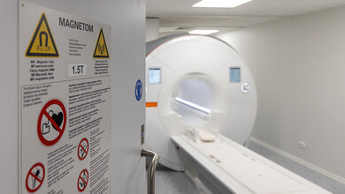 Sicherheit geht vor! Foto mit Blick durch eine geöffnete Tür mit Sicherheitshinweisen auf ein Magnetom