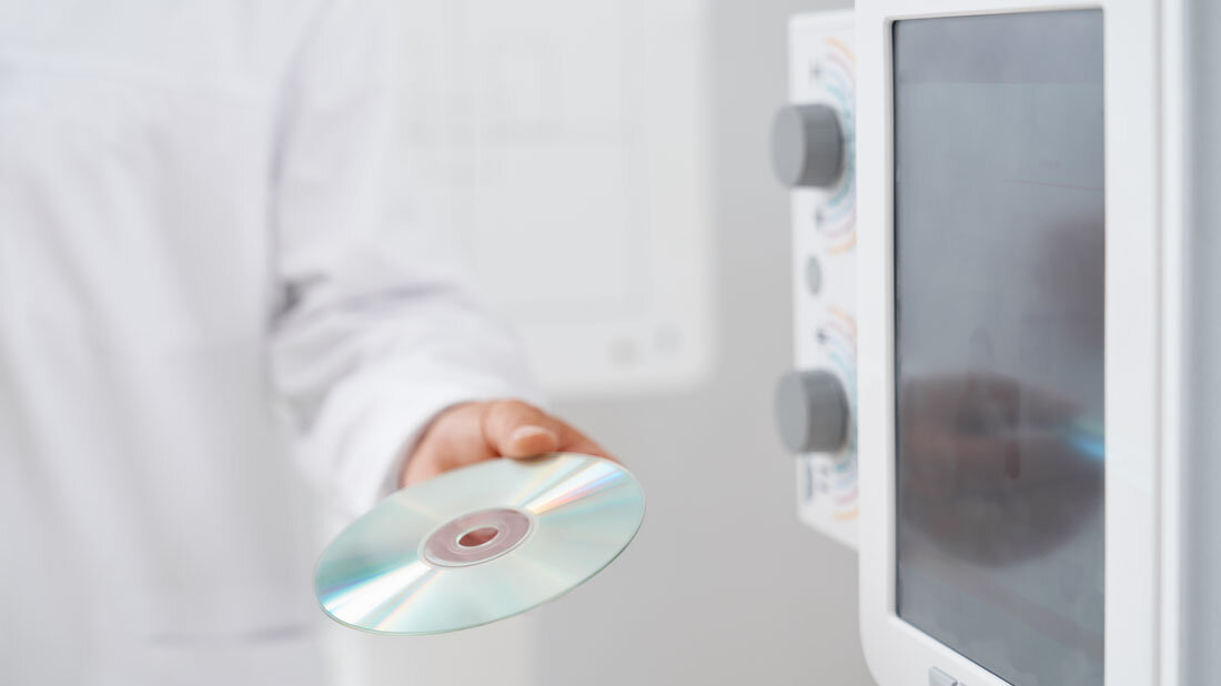 CD_in_der_Radiologie.jpg Arzt überreicht in der Radiologie eine CD mit Daten.