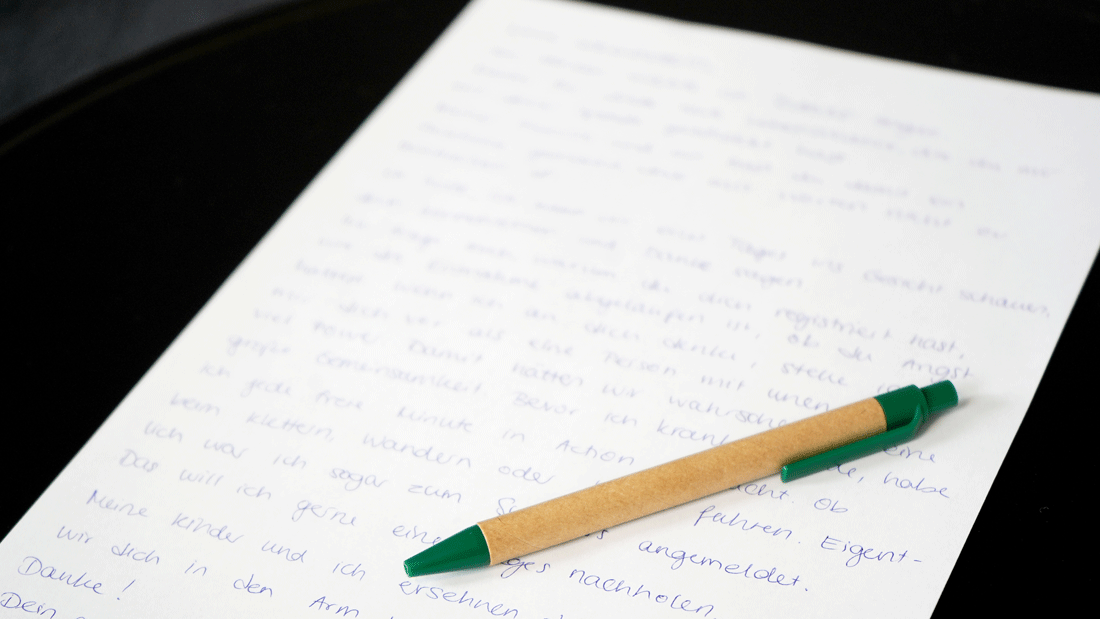 DSC06048.gif Handgeschriebener Brief auf weißem Papier mit grünem Kugelschreiber auf dunkler Unterlage
